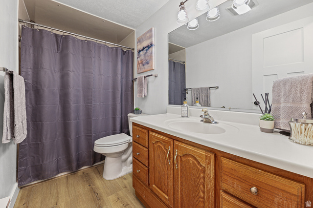 822 Pinewood Circle Price, UT 84501 - Photo 17 of 49 Bathroom featuring a wood-finish vanity with a white countertop and integrated sink, a large wall-mounted mirror, and overhead vanity lighting