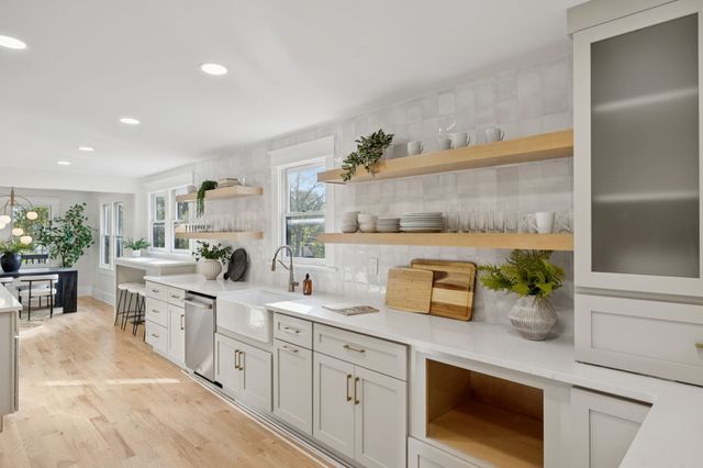 a kitchen with white cabinets and window