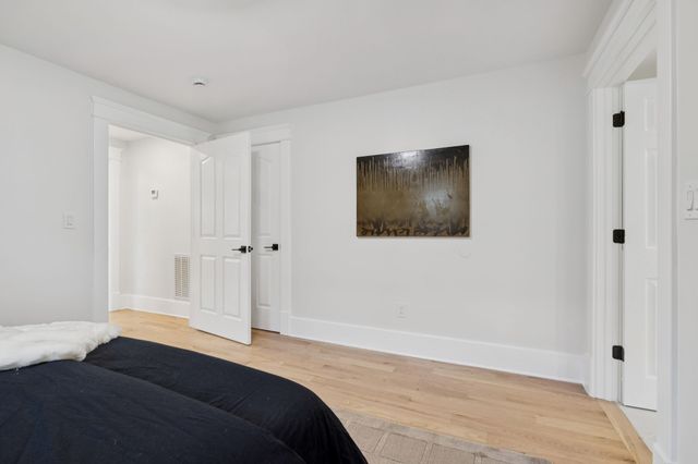 a bedroom with a bed and a painting on the wall