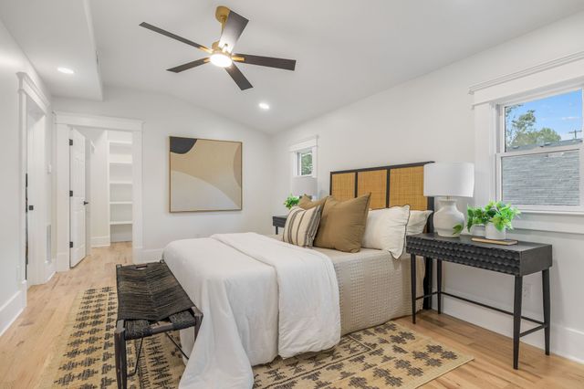 a bedroom with a bed lamp and a potted plant