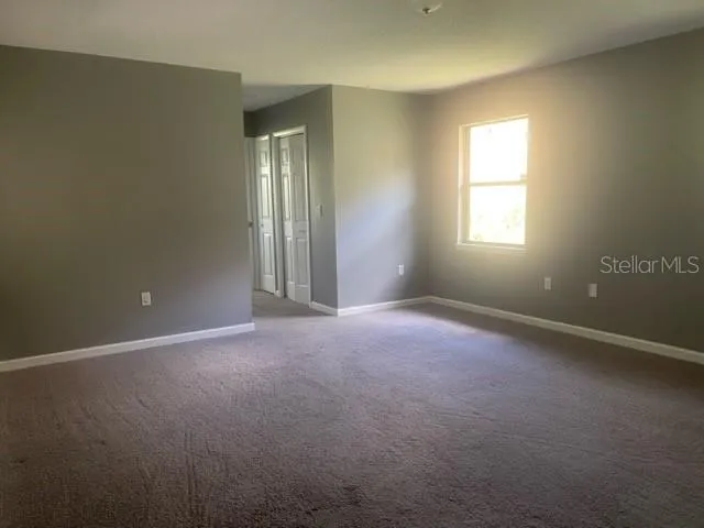 an empty room with windows and closet