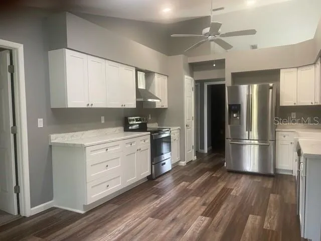 a kitchen with stainless steel appliances a refrigerator sink and cabinets