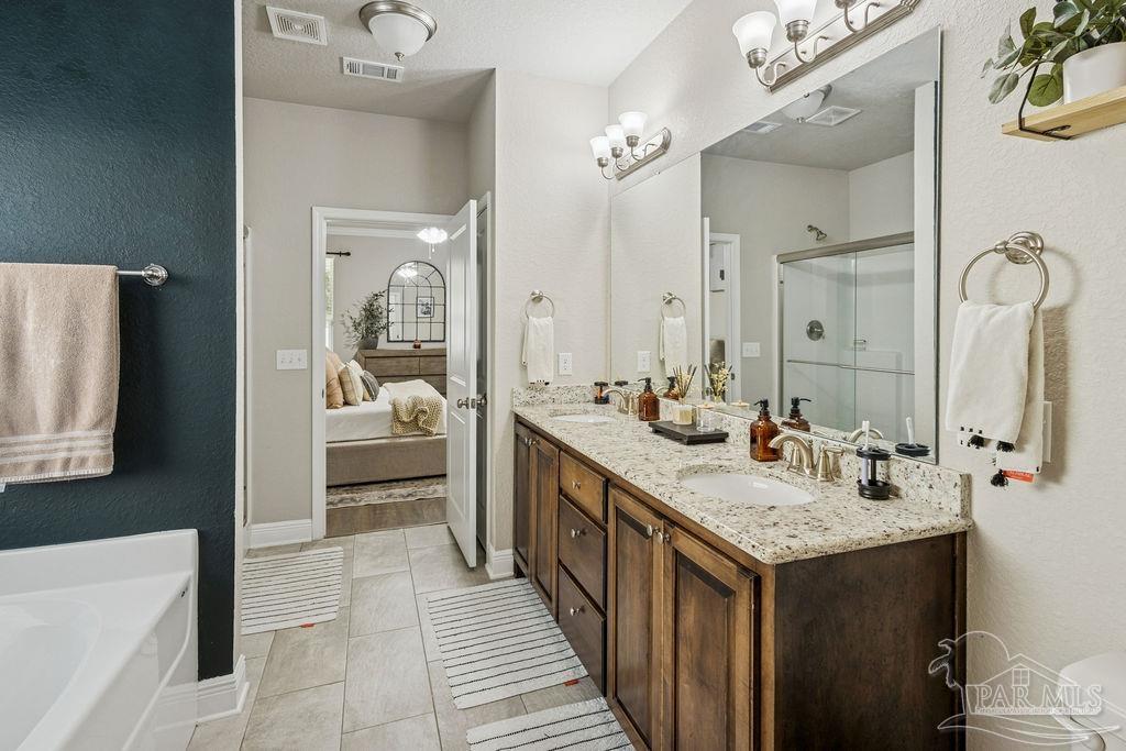 5392 Parkside Drive Pace, FL 32571 - Photo 17 of 28 a en suite bathroom with a double vanity sink a mirror and shower