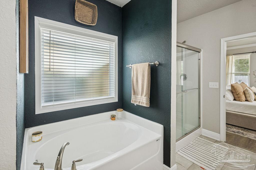 5392 Parkside Drive Pace, FL 32571 - Photo 18 of 28 a bathroom with a bathtub and a shower
