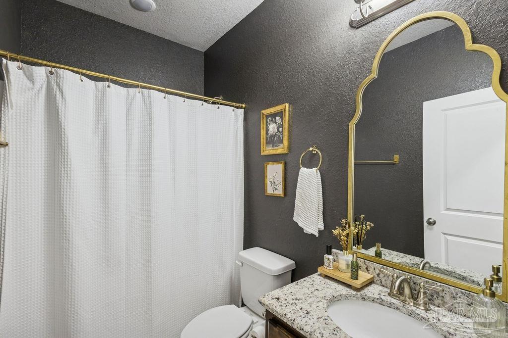 5392 Parkside Drive Pace, FL 32571 - Photo 2 of 28 a bathroom with a granite countertop sink vanity mirror and toilet