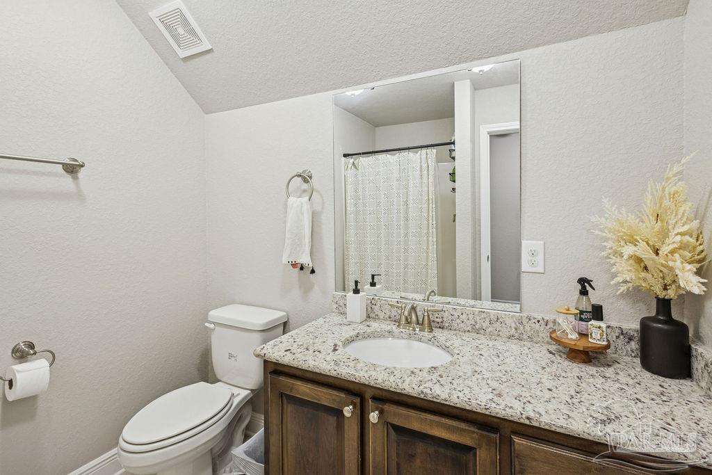 5392 Parkside Drive Pace, FL 32571 - Photo 21 of 28 a bathroom with a granite countertop sink a toilet and a mirror