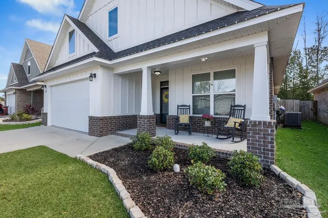 a view of a house with backyard and sitting area