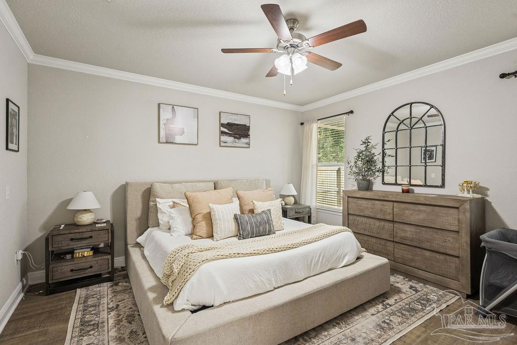 5392 Parkside Drive Pace, FL 32571 - Photo 3 of 28 a bedroom with a large bed and a chandelier