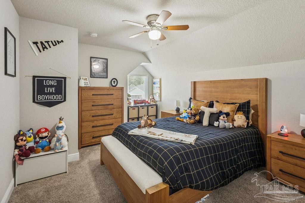 5392 Parkside Drive Pace, FL 32571 - Photo 8 of 28 a bedroom with a bed and a chandelier