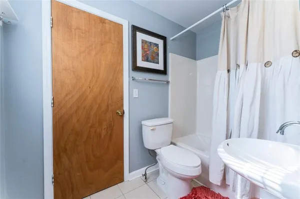 a white toilet sitting next to a bathroom sink and a shower