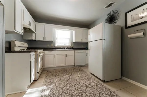 a kitchen with white cabinets and white appliances