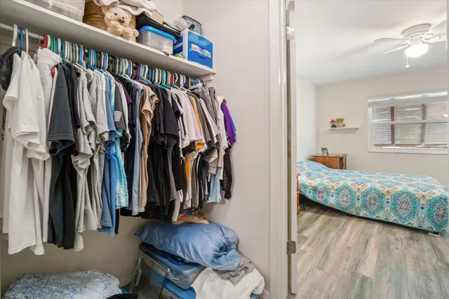 a view of walk in closet with clothes and shoes