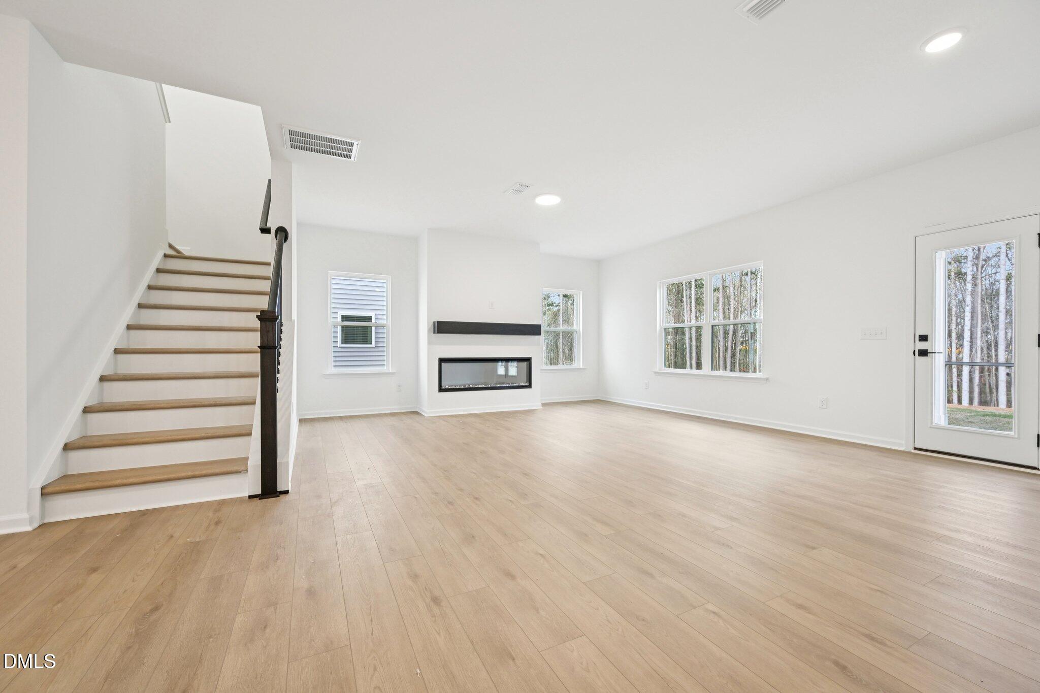 916 Fetching Place, Unit 344 Rolesville, NC 27571 - Photo 11 of 37 a view of a livingroom with wooden floor and a window