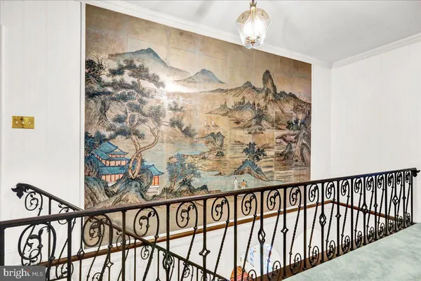 a view of a hallway to a livingroom with wooden floor and windows