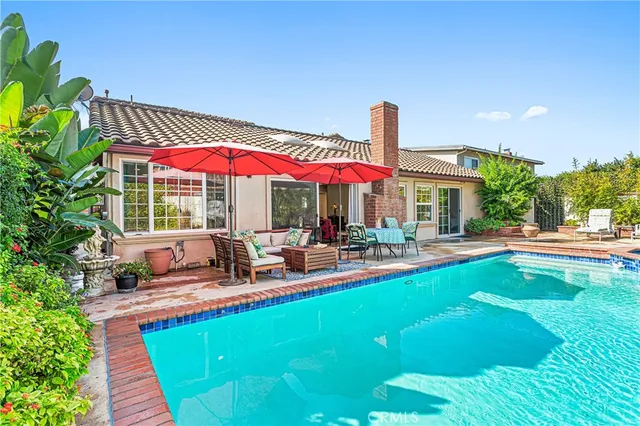 a view of a house with swimming pool and sitting area