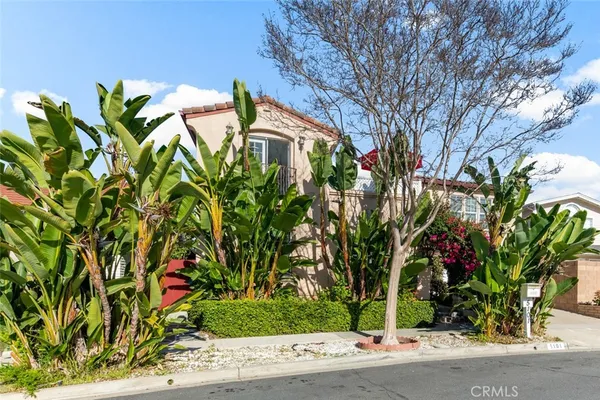 a front view of a house with a yard and fountain in middle