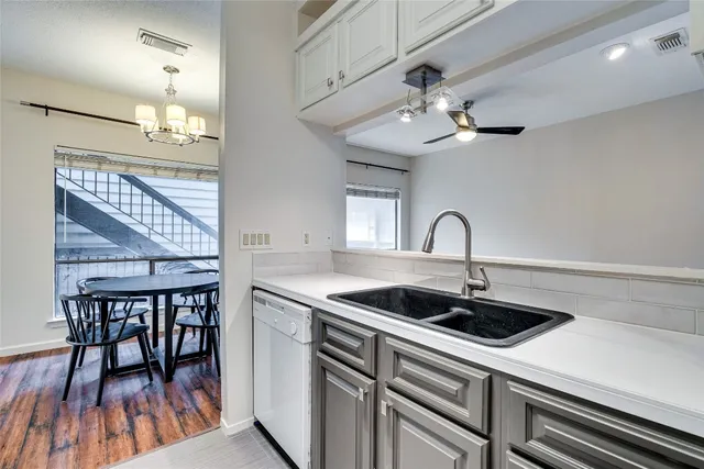 a kitchen with a table chairs and white cabinets
