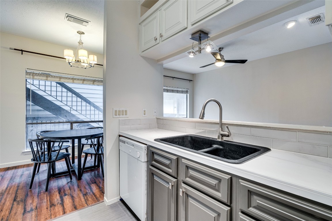 908 Poplar Street, Unit 208 Austin, TX 78705 - Photo 15 of 26 a kitchen with a table chairs and white cabinets