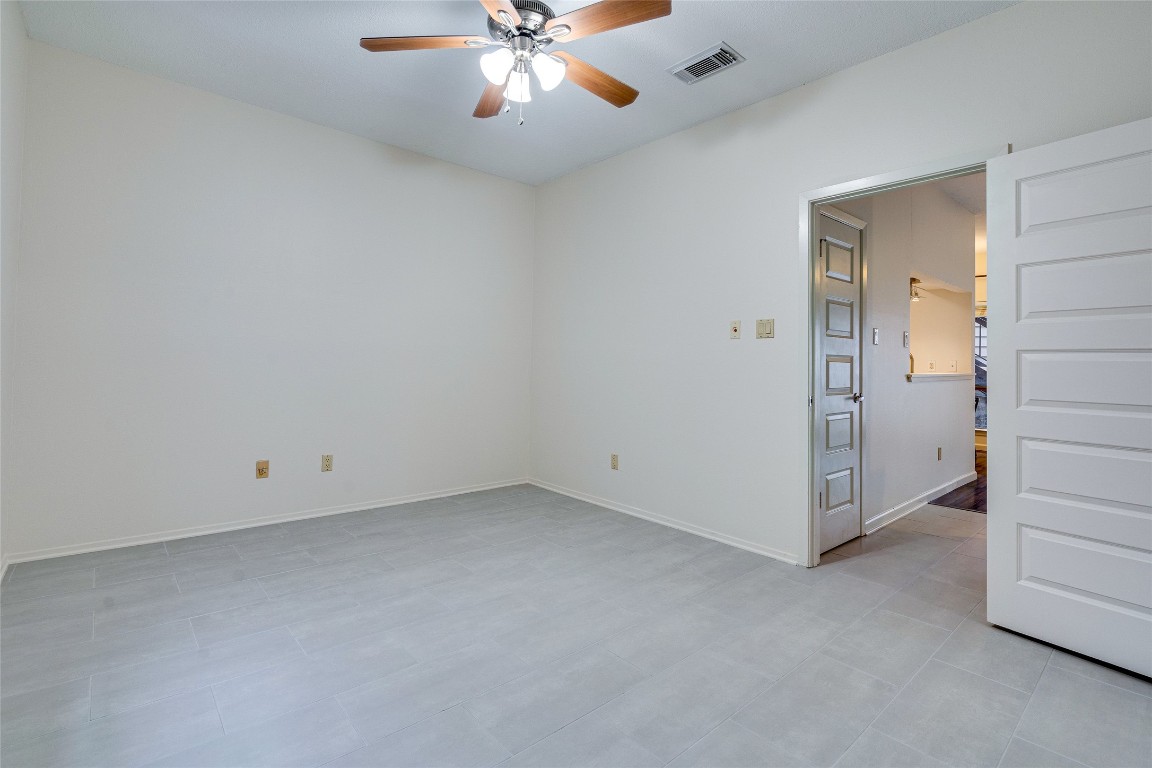 908 Poplar Street, Unit 208 Austin, TX 78705 - Photo 21 of 26 an empty room with chandelier fan and windows