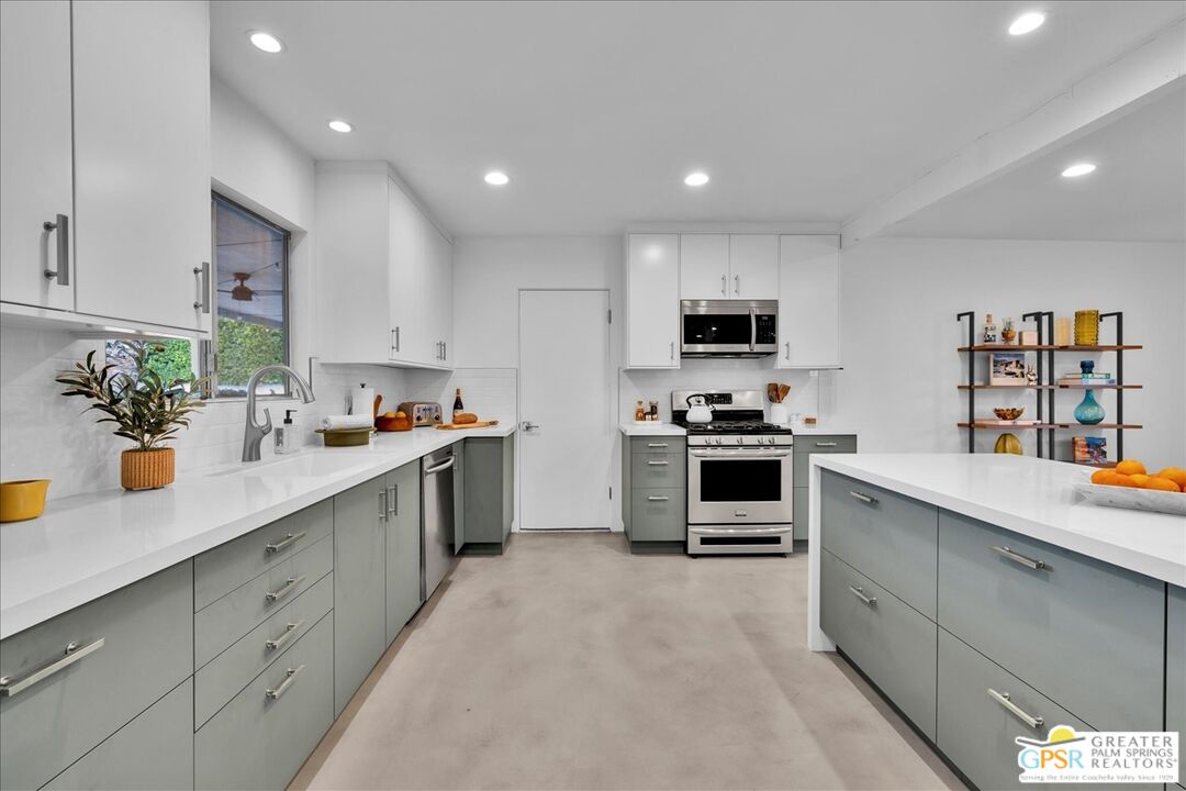2210 East Powell Road Palm Springs, CA 92262 - Photo 8 of 71 a kitchen with granite countertop white cabinets and stainless steel appliances