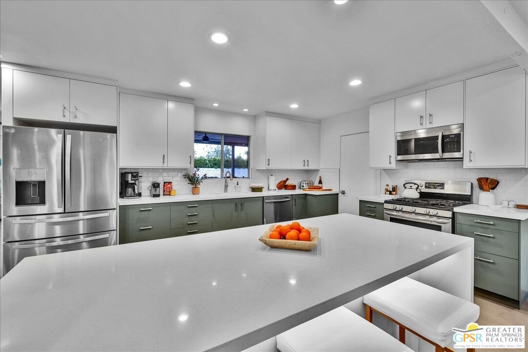 2210 East Powell Road Palm Springs, CA 92262 - Photo 9 of 71 a kitchen with stainless steel appliances a refrigerator sink stove microwave and cabinets