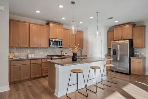 a kitchen with stainless steel appliances granite countertop a stove a sink a refrigerator and a microwave