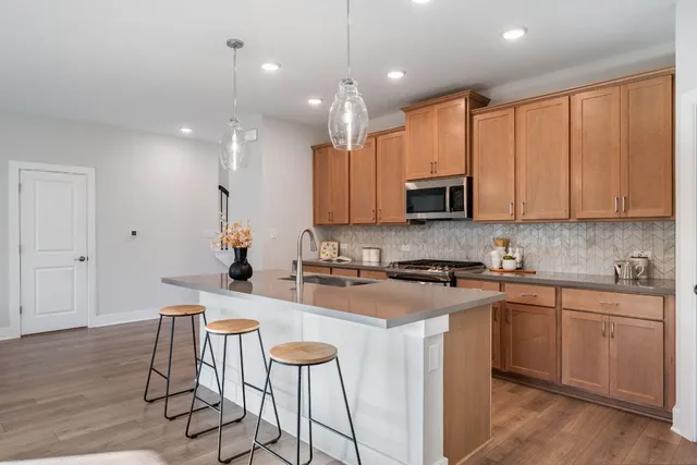 a kitchen with kitchen island granite countertop wooden cabinets and a refrigerator