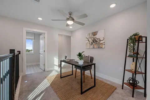 a view of a workspace with furniture and a window