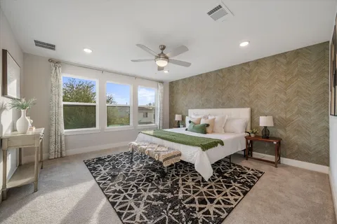 a bed sitting in a spacious bedroom next to a window