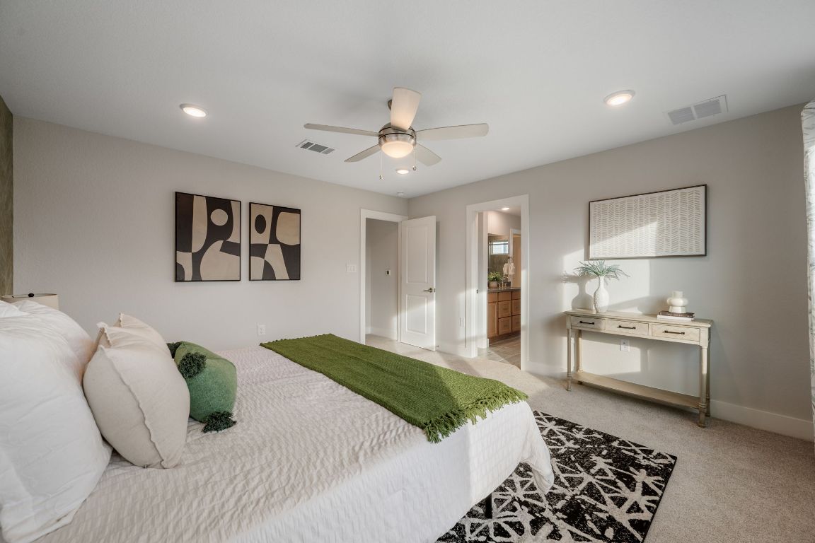 1403 Iberville Drive Pflugerville, TX 78660 - Photo 24 of 40 a bedroom with a large bed and a chandelier