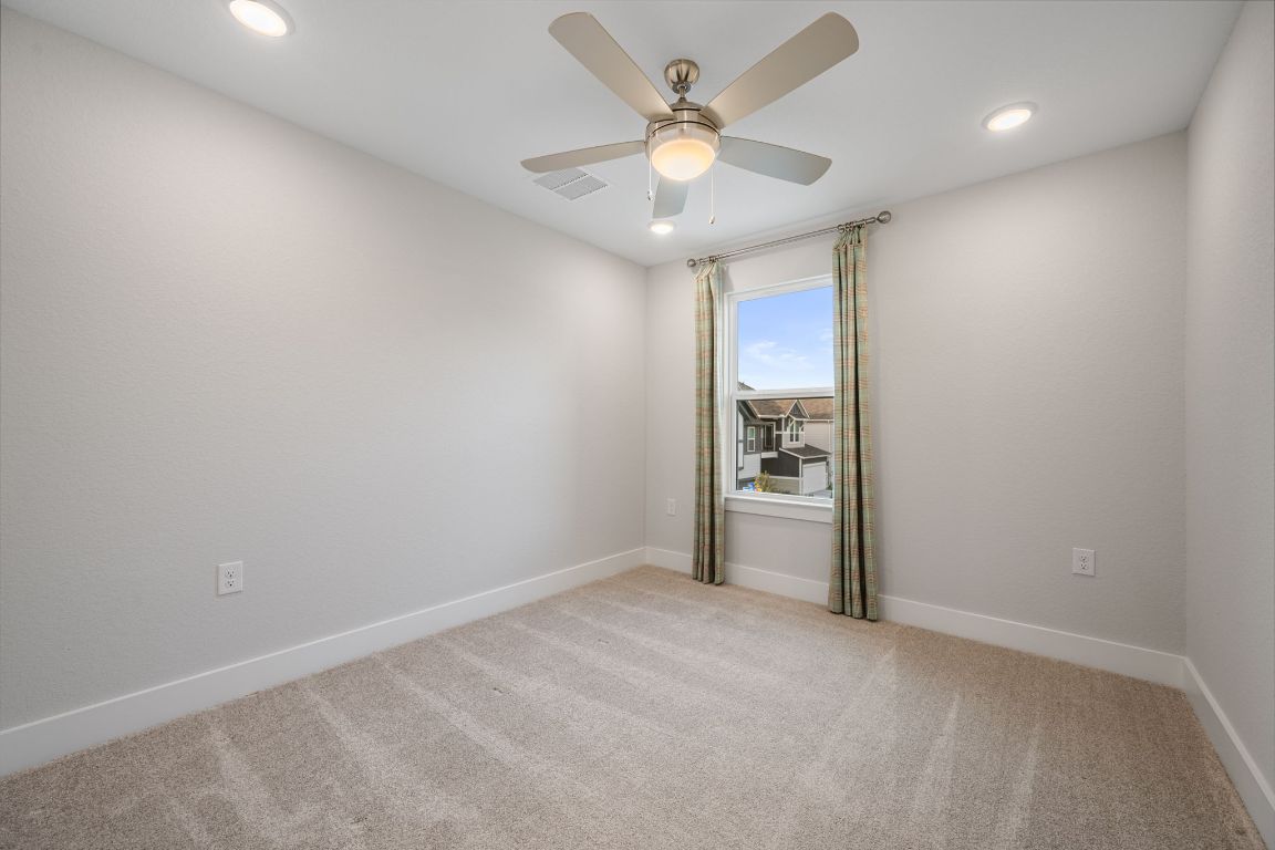 1403 Iberville Drive Pflugerville, TX 78660 - Photo 31 of 40 an empty room with a chandelier fan and windows