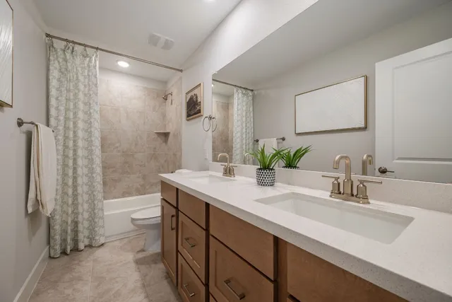 a bathroom with a double vanity sink toilet and shower