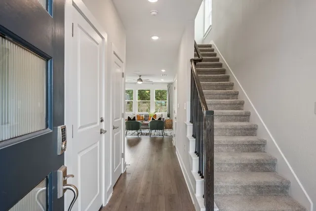 a view of hallway with wooden floor and stairs