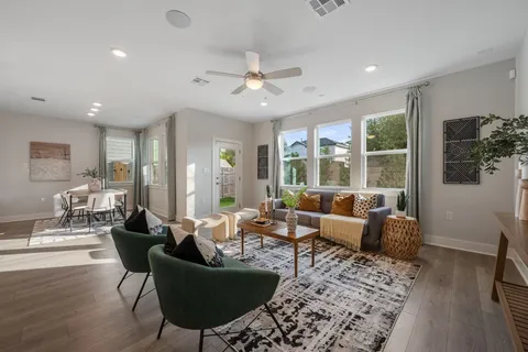 a living room with furniture potted plant and a large window