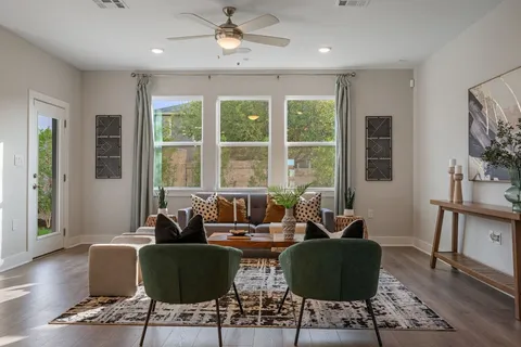 a living room with furniture and two large window