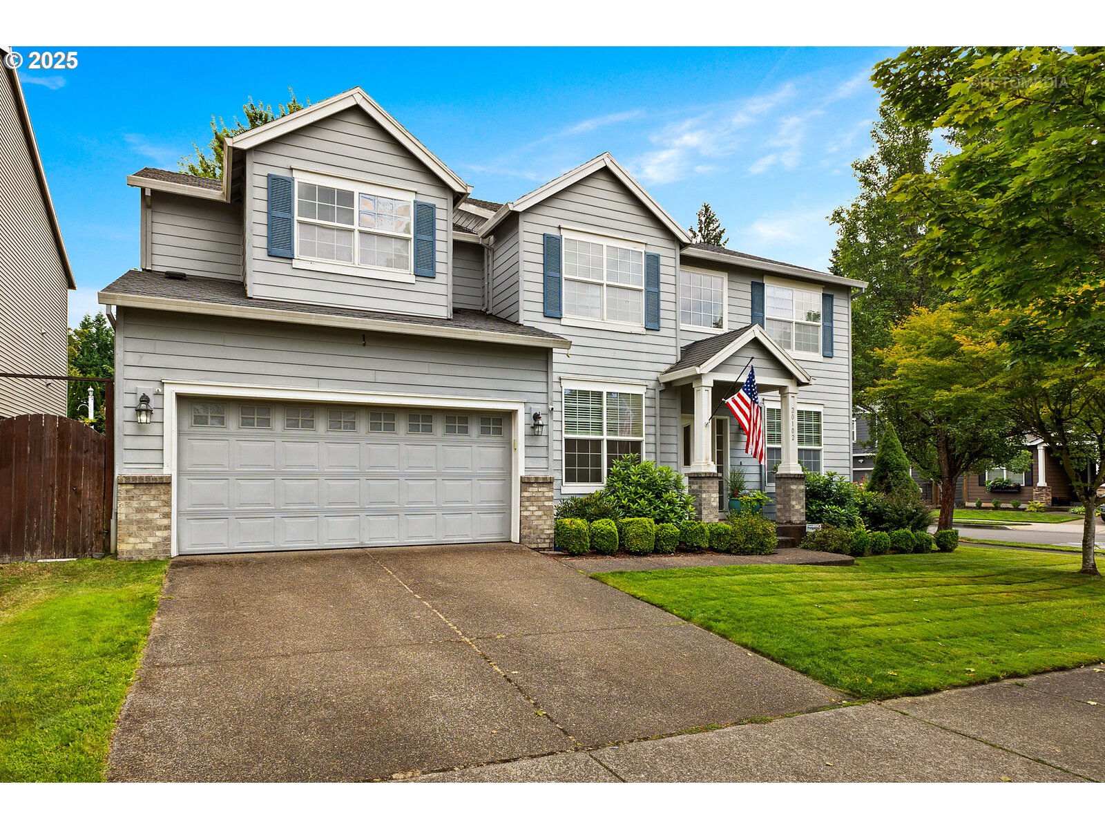 20102 Southwest 54th Terrace Tualatin, OR 97062 - Photo 2 of 35 a front view of a house with a yard and garage