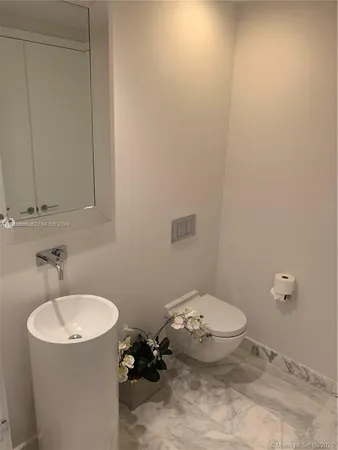 a bathroom with a sink toilet and a mirror