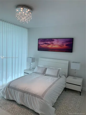 a bedroom with a bed and a chandelier