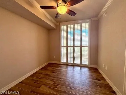a view of an empty room with window and wooden floor