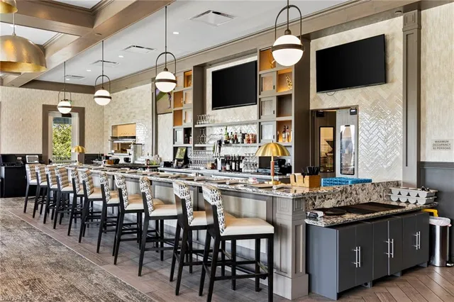 a kitchen with stainless steel appliances granite countertop a stove top oven a sink dishwasher a dining table and chairs with wooden floor