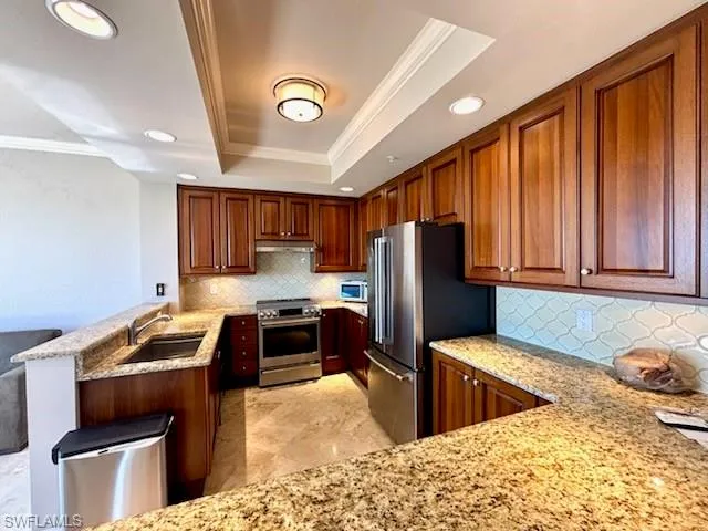 a kitchen with stainless steel appliances granite countertop a refrigerator stove and sink