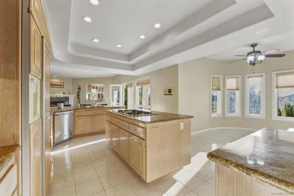 a kitchen with granite countertop a sink stove and refrigerator