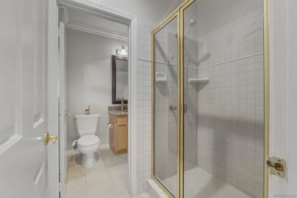 a bathroom with a granite countertop toilet and a shower