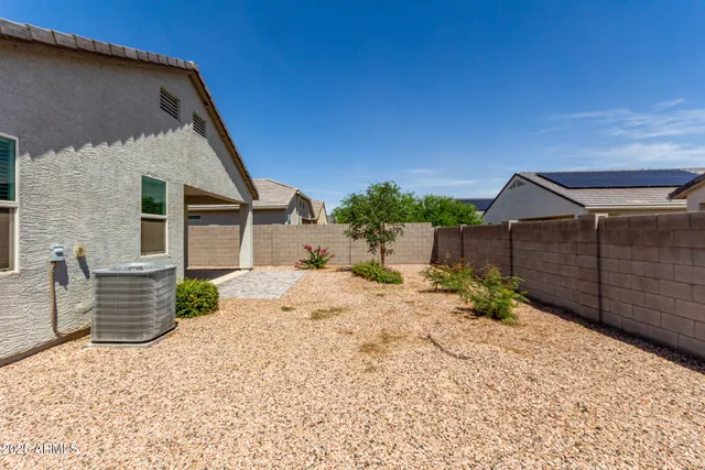 a backyard of a house with wooden fence and a potted plant