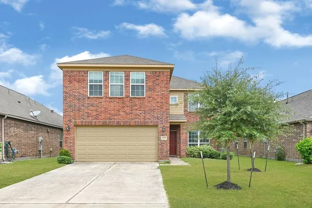 a front view of a house with a yard and trees