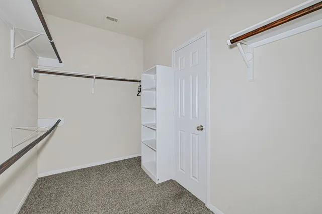a view of walk in closet with empty racks