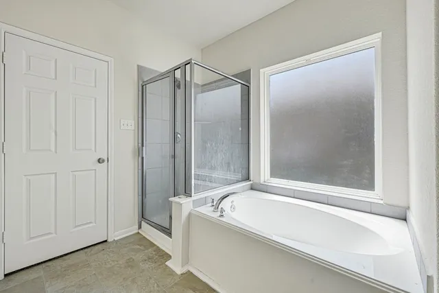 a bathroom with a bathtub and a shower
