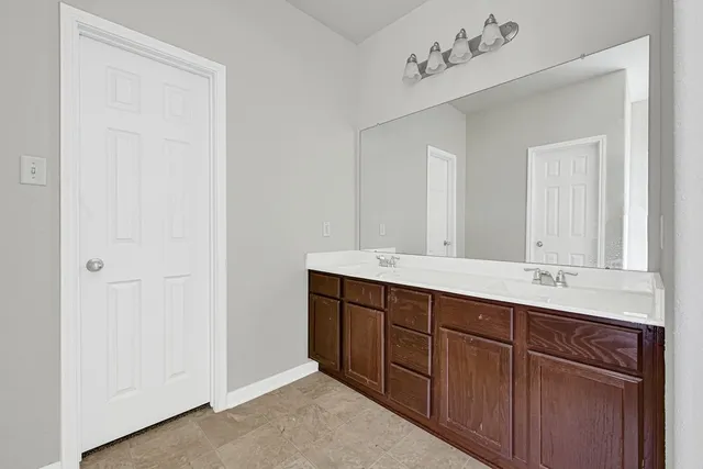 a bathroom with a double vanity sink and a mirror