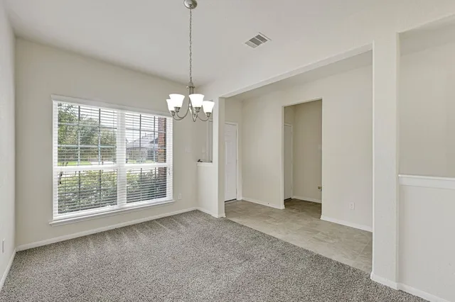 a view of a livingroom with a chandelier fan and windows