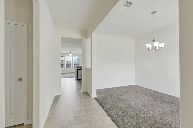 a view of a hallway with wooden floor and a kitchen